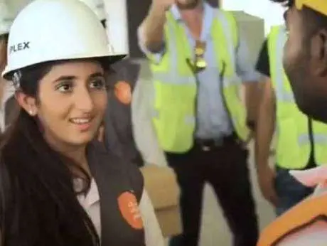 Shaikha Sama Bint Mohammed entrega una caja de comida a un trabajador.