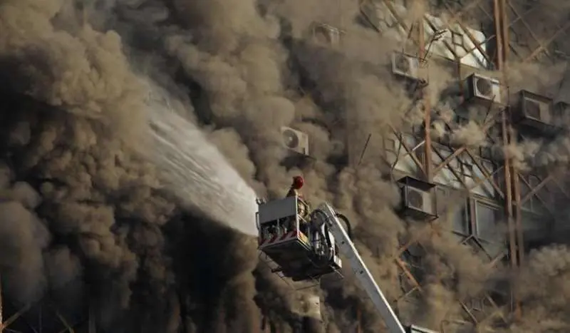 Bomberos intervinienen en la extinción del edificio que se ha derrumbado en Teherán. (@Hispantv)