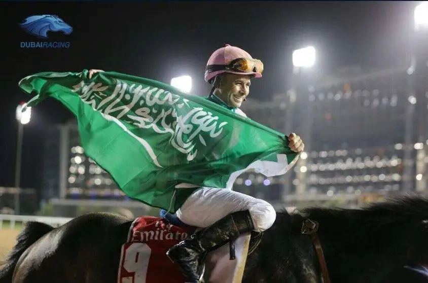 Mike Smith levanta una bandera de Arabia Saudita tras ganar la Dubai World Cup.