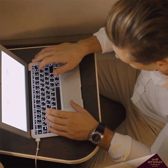 Un pasajero consulta su ordenador en un avión de Etihad. (Etihad Airways)