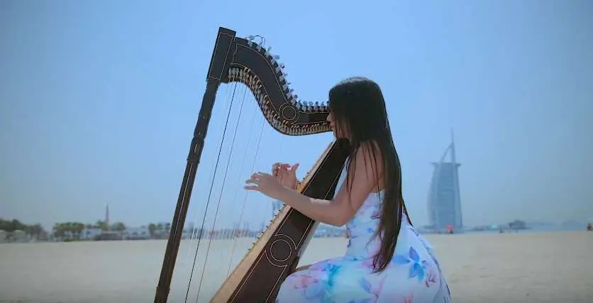 Luz Verón y su arpa en la playa del Burj Al Arab de Dubai.