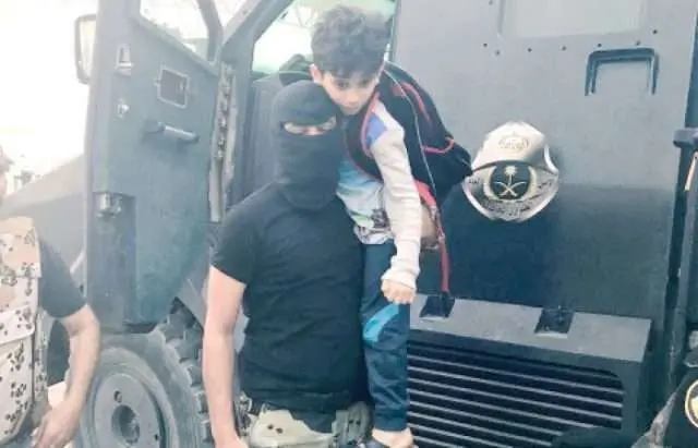 Un militar saudí ayuda a un chico de la zona de Al-Masourah. (Saudi Gazette)