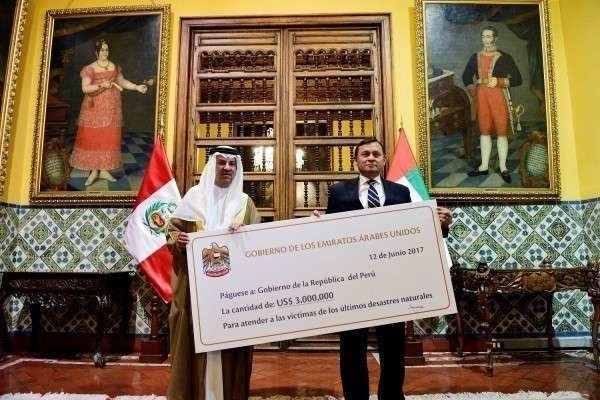 El embajador de Emiratos en Perú, Mohammed Yusouf Al Awadi, entrega un cheque al viceministro de Relaciones Exteriores de Peru, Nestor Francisco Popolizio. (WAM)