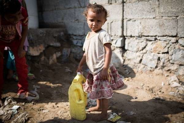 Una niña recoge agua en Yemen.