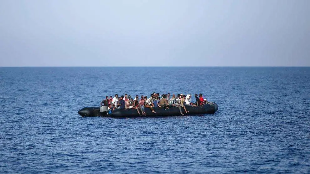 En la imagen de AFP, un grupo de migrantes espera ser rescatado por la Guardia Costera italiana en el Mediterráneo.