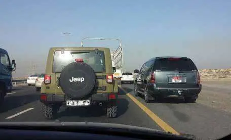 Varios vehículos circulan por el arcén de una carretera.