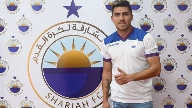 César Pinares posa ante el escudo del Sharjah C.F.