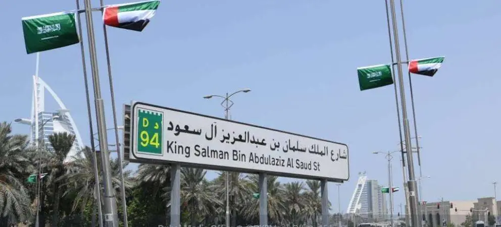 La calle King Salman Bin Abdul Aziz engalanada con baderas saudíes y emiratíes en Dubai.