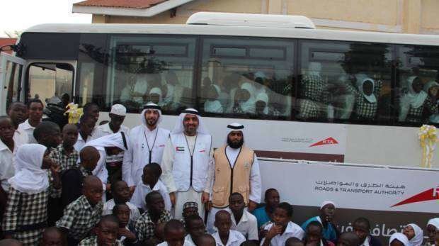 Integrantes de la delegación de la RTA con uno de los autobuses donados a los escolares africanos. (RTA)