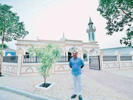 Saji Cheriyan delante de la mezquita que ha construido para los trabajadores.