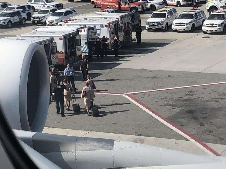 Tripulantes de cabina de Emirates se dirigen a las ambulancias en el aeropuerto de Nueva York.