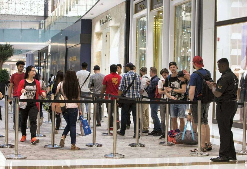 Los fanáticos de Apple esperan en fila en la tiende de Apple en Dubai Mall. (Leslie Pableo / The National)