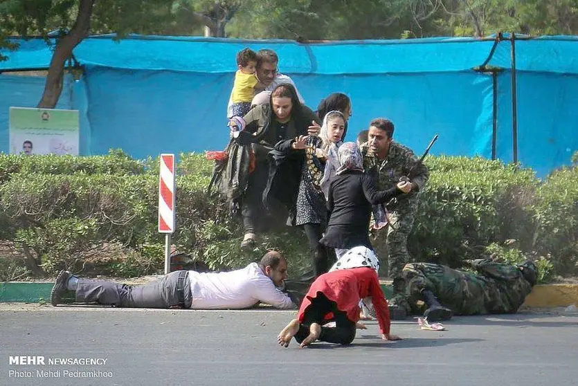 Asistentes al desfile militar en el sur de Irán intentan esquivar la lluvia de balas. (MEHR NEWS AGENCY / MEHDI PEDRAMKHOO)