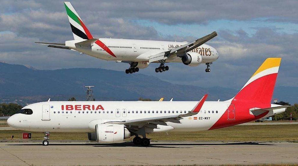 Un avión de Iberia junto a uno de Emirates.