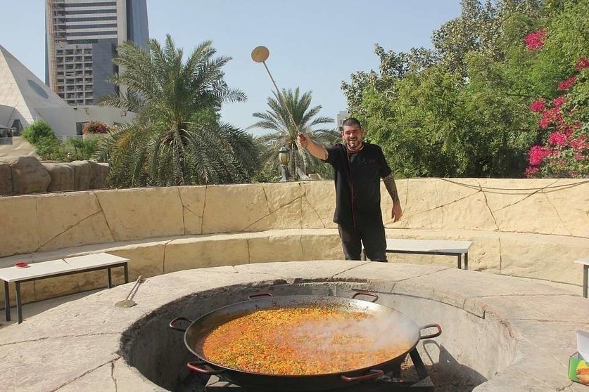 El chef del Seville's, Aleix Font, junto a la enorme paella que el restaurante preparó para la ocasión. (EL CORREO)