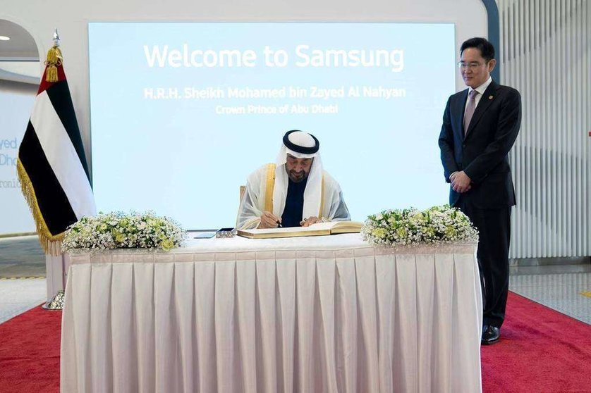 El príncipe heredero de Abu Dhabi firma en el libro de visitas de la empresa Samsung.