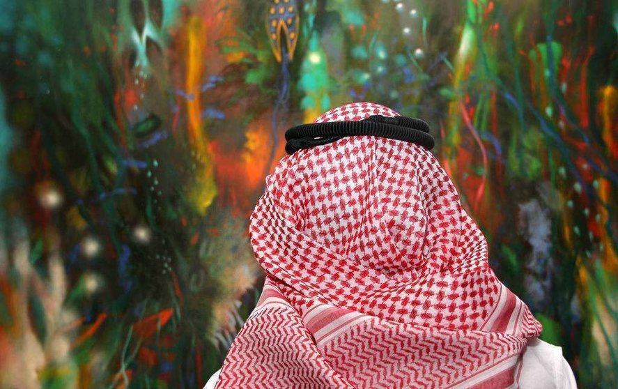 Ciudadano árabe contempla en Dubai la obra 'El jardín de las hadas' de Carlos Jacanamijoy. (R. Pérez)