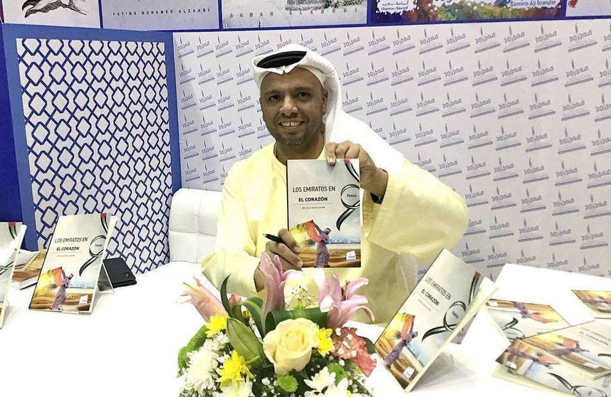 El poeta emiratí Talal Said Aljunaibi muestra su obra en español 'Los Emiratos en el corazón' durante la 38 edición de la Feria Internacional del Libro de Sharjah. (EL CORREO)
