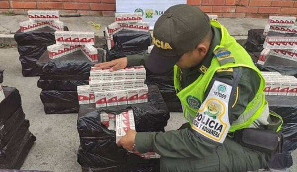 Un oficial colombiano con las cajetillas de tabaco. (Caracol Radio)