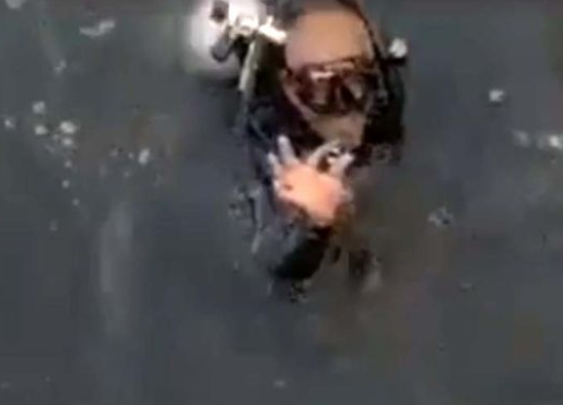 El buzo posa con el anillo recuperado.