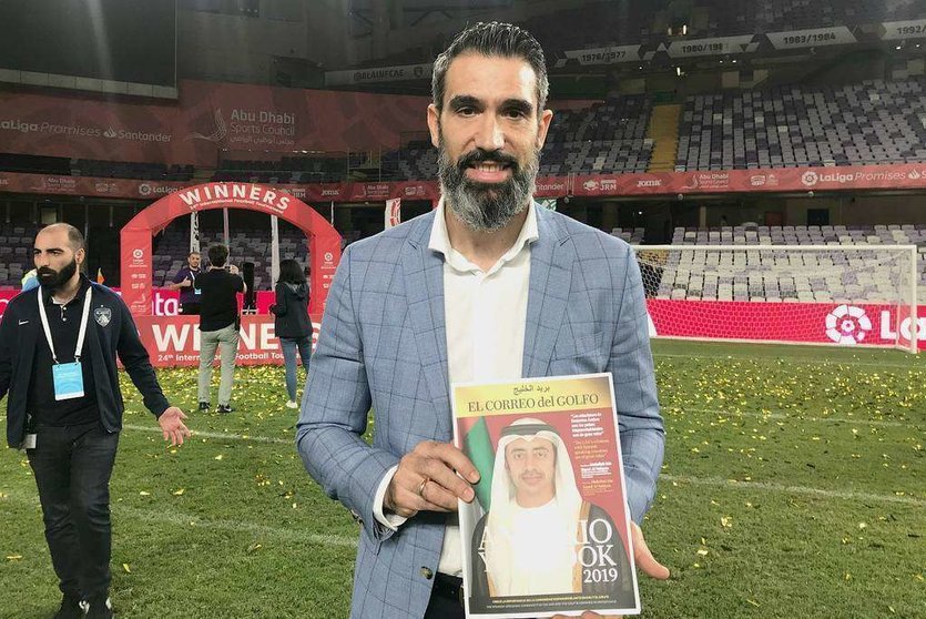 Fernando Sanz muestra un ejemplar del Anuario 2019 de EL CORREO DEL GOLFO en el estadio Hazza Bin Zayed de Al Ain. (EL CORREO)