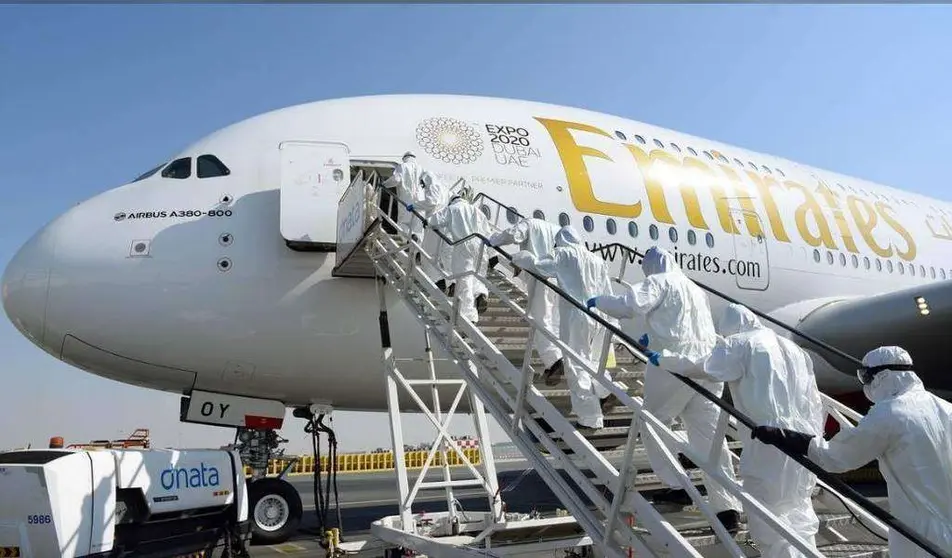 Personal de limpieza accede a un avión de Emirates.