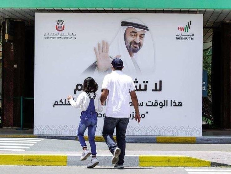 Un padre y su hija caminan por una calle de EAU. (The National)