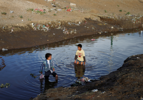En la imagen de Reuters, dos niños juegan en aguas residuales en la capital de Yemen, Saná.