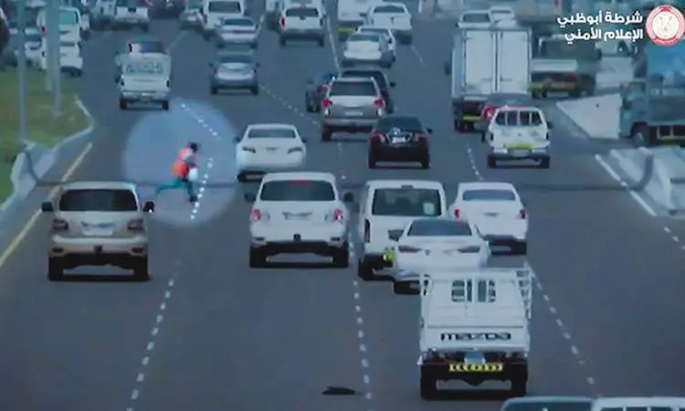 Una captura del vídeo de la Policía de Abu Dhabi muestra al hombre cruzando la calle, causando confusión entre los automovilistas.