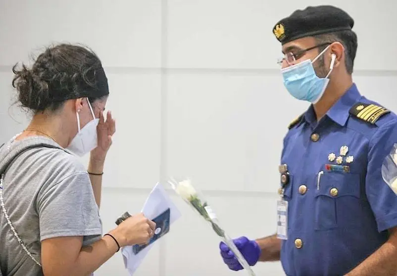 Mujer libanesa, emocionada ante la rosa blanca que le entrega Dubai. (WAM)