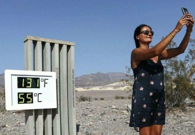 Una visitante frente a un termómetro no oficial en el Parque Nacional Death Valley en California. (Twitter)