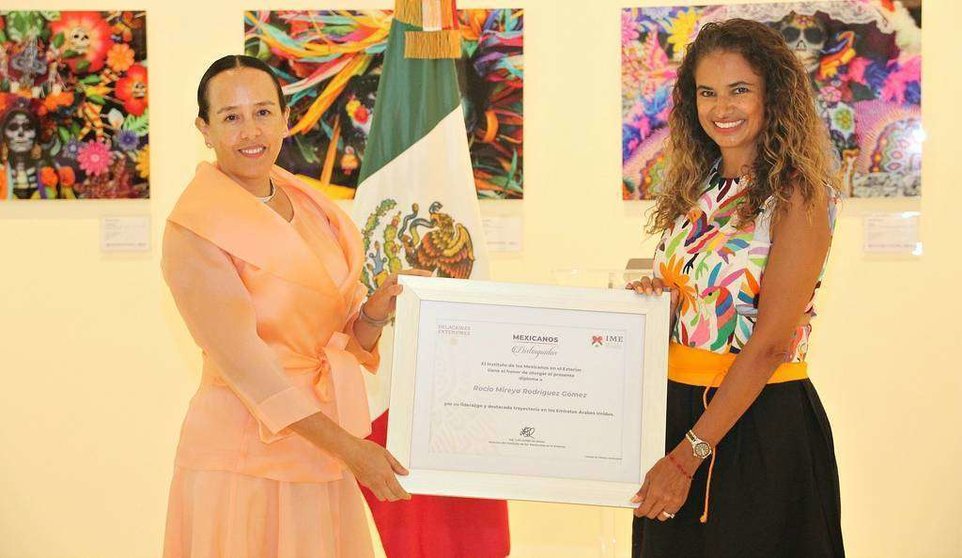 La embajadora de México en EAU, Francisca E. Méndez, entrega a Rocío Mireya Rodríguez el diploma que la acredita como 'Mexicana Distinguida'. (EL CORREO)