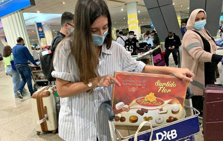 La andaluza Celia Pérez, procedente de Madrid, a su llegada en la medianoche del miércoles a un abarrotado Aeropuerto Internacional de Dubai con una caja de los exquisitos dulces de Navidad de la Flor de Rute. (EL CORREO)