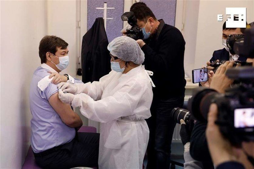 El médico sanitario jefe de Kazajistán, Yerlan Kiyasov (izquierda), recibe la primera dosis de la vacuna rusa Sputnik V contra el coronavirus en Nur-Sultán, Kazajistán, este lunes. (Efe)