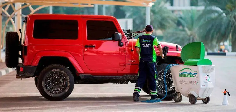 Un trabajador de Emirates Transport lava en seco un vehículo. (WAM)