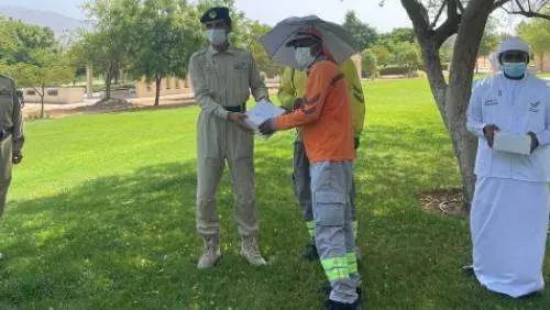 Policía repartiendo comida a los trabajadores. (Khaleej Times)