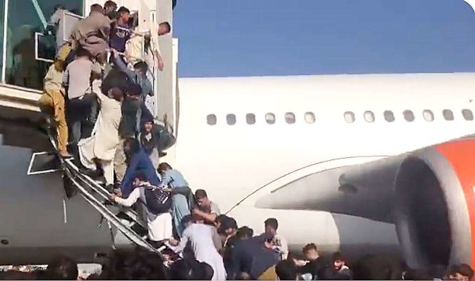 Decenas de personas asaltan el acceso de un avión en el aeropuerto de Kabul. (@NicolaCareem)