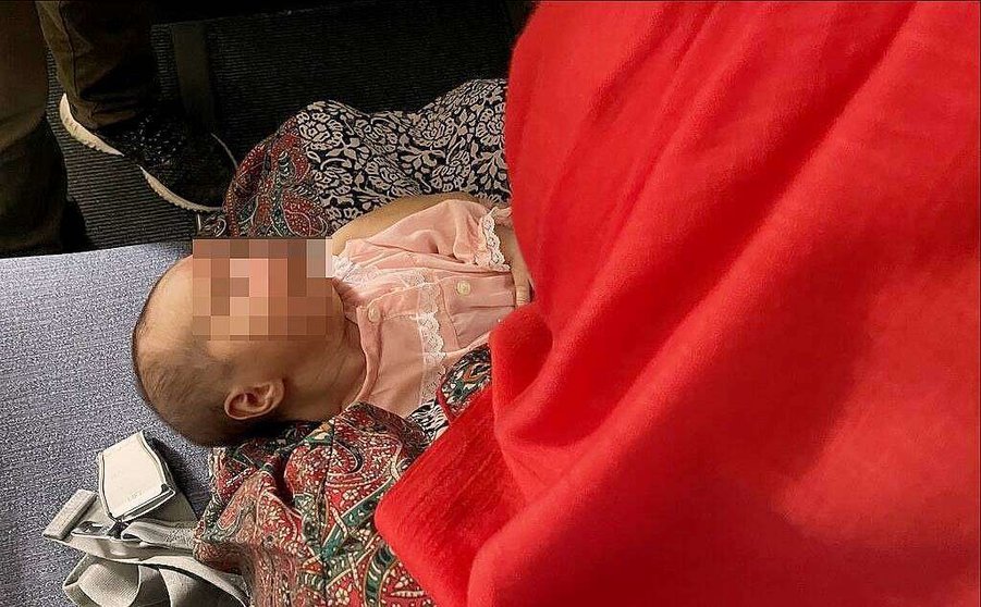 Niña afgana de 25 días en brazos de su madre en el avión en que fue trasladada desde Dubai a Madrid por España. (EL CORREO)