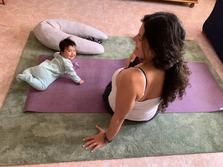 Bebe junto a su madre haciendo yoga.