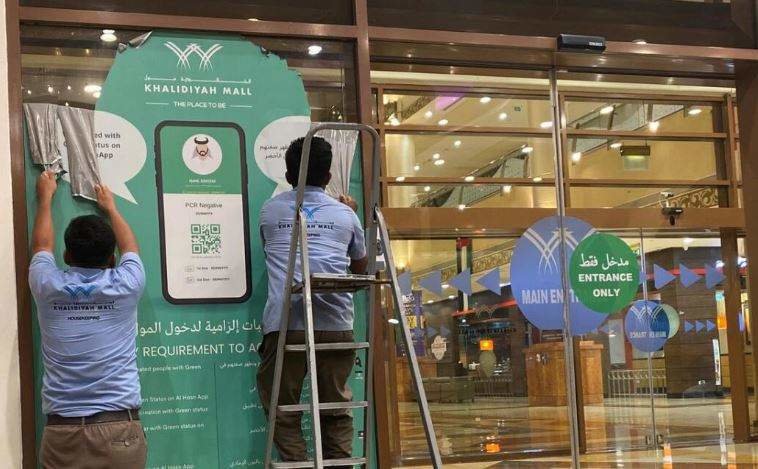 Trabajadores retiran las etiquetas de Al Hosn en un centro comercial de Abu Dhabi. (Fuente externa)
