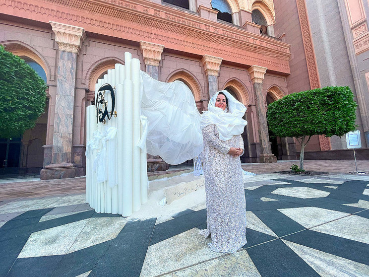 La artista sevillana Mercedes Eirín en el Emirates Palace de Abu Dhabi ante su obra 'Las dunas infinitas' vestida con un modelo de la diseñadora andaluza Susana Álvarez. (EL CORREO)