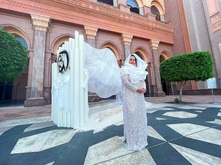 La artista sevillana Mercedes Eirín en el Emirates Palace de Abu Dhabi ante su obra 'Las dunas infinitas' vestida con un modelo de la diseñadora andaluza Susana Álvarez. (EL CORREO)