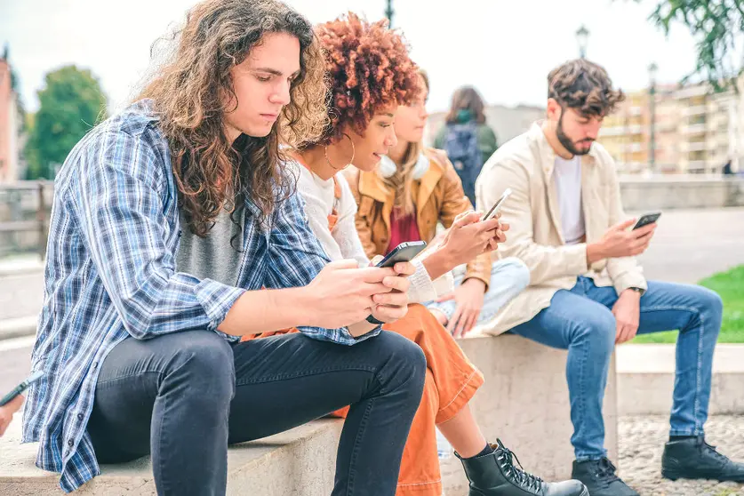 Numerosas personas atienden hoy antes a la pantalla de su teléfono que a la vida que pasa ante ante sus ojos. (Bruby)