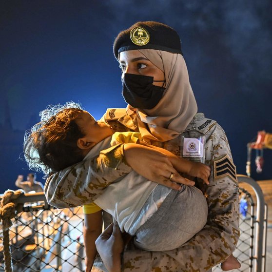 Un niño se queda dormido en brazos de una empleada del Ministerio de Defensa saudí. (Instagram pplofsaudia)