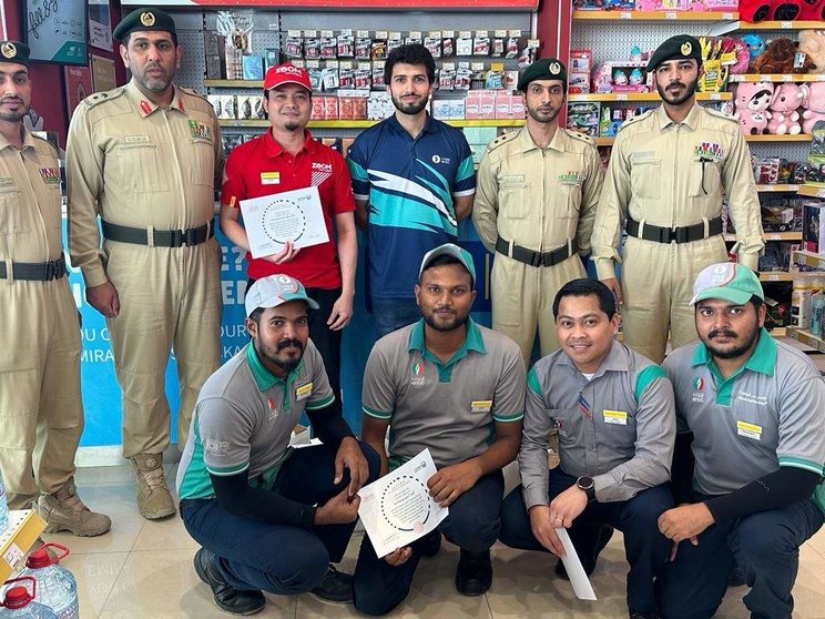 Los trabajadores de la gasolinera de Enoc junto a oficiales de la Policía de Dubai. (Twitter)