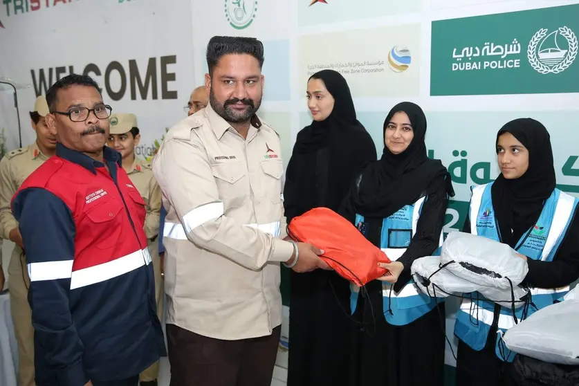 Miembros de la Policía de Dubai entregan ropa a trabajadores en Jebel Ali. (Twitter)