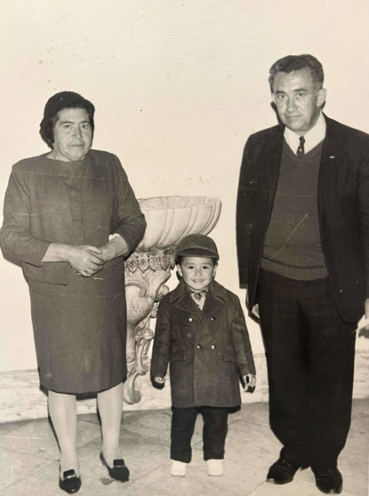 Dixon Moya, autor del texto, con sus padres-abuelos, vestido de una especie de niño Mao, con chaqueta y boina verde oliva, durante su bautismo en Colombia.