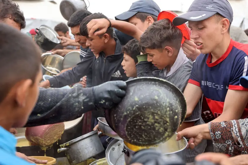 Palestinos esperan comida en Gaza. (WAM)