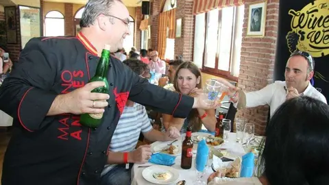 Mariano Andrés sirve sidra durante el Día de Asturias celebrado en el restaurante Seville's. (EL CORREO)