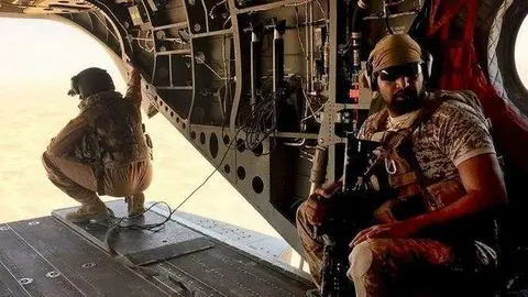 Un soldado y un aviador de Emiratos en un helicóptero Chinook en la zona de Marib. (Reuters)